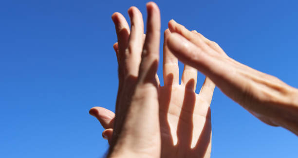 istock Business success and teamwork. Three hands high five over blue sky with copy space 1952528006