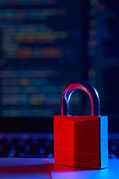 istock Internet security concept. Vertical shot of lock over laptop with code in the background lit with blue and red lights 1952530140