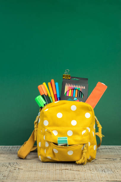 istock Backpack with different colorful stationery on table. Green background. Back to school. 1952531740