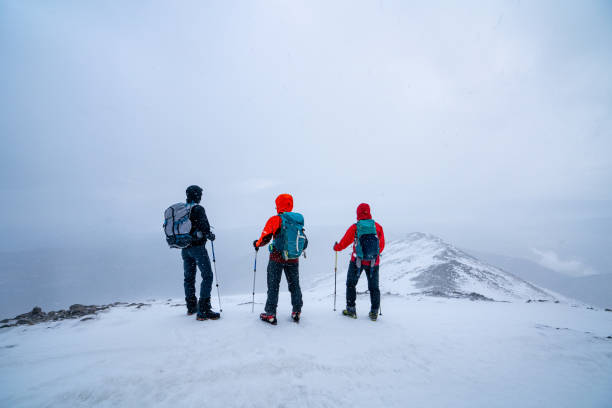 istock Mountain climber team is looking at the scenery while  standing on the summit of a high altitude mountain. 1952549076