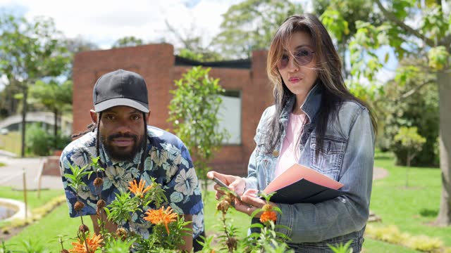 Portrait of botany students examining flowers outdoors