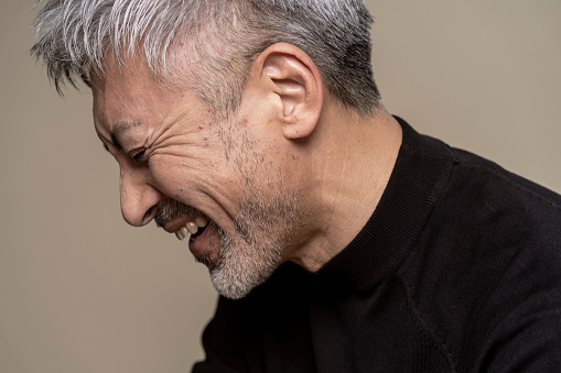 A middle-aged man with a beard and gray hair is smiling.