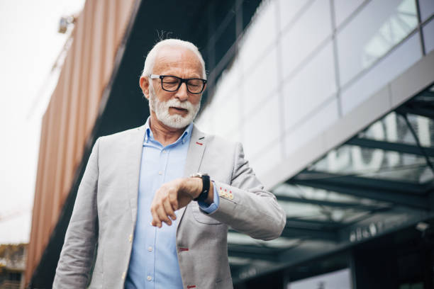 istock A handsome mature man is walking outside while checking the time on his watch 1952576620