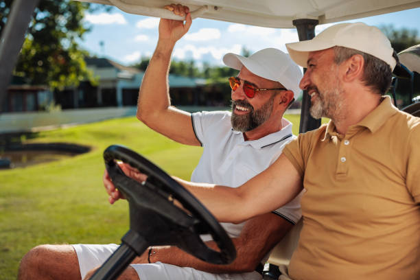 istock Two golfers in a golf cart driving and laughing 1952577130