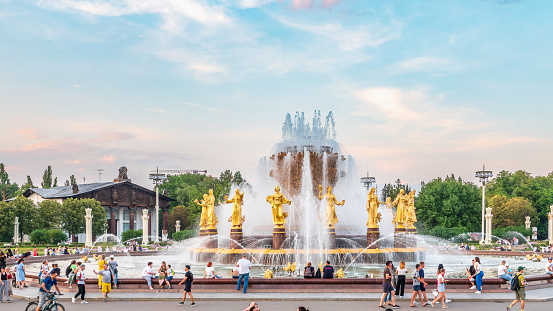 Moscow, Russia - August 4, 2022: The Peoples Friendship Fountain in VDNKh park in Moscow. Amazing sunny view of the Soviet architecture, landmark of Moscow. Beautiful luxurious old fountain in summer. Famous touristic place