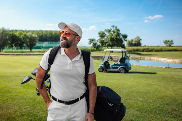 istock Attractive mature golfer waking down the golf field, smiling 1952582981