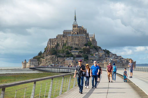 Normandy, France –Aug 29,2023: Tourists walking in front of the Mont Saint-Michel
