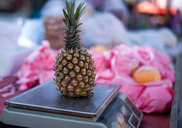 Weighing pineapples in supermarket