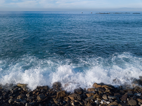 Atlantic ocean from a rocky beach in south of Tenerife, canary islands. View of the horizon over the sea and blue sky, view of breeding of sea bass