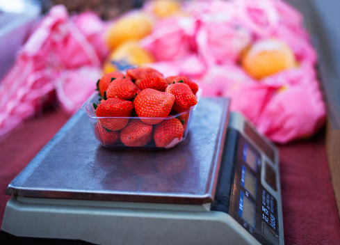 Weighing strawberries in supermarket