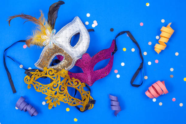 金、紫、白の3つの仮面が羽根で飾られ、青い背景に隔離されています - carnival costume mask masquerade mask ストックフォトと画像