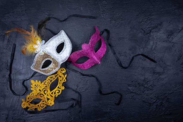 3つの鮮やかな色のマスクを一緒にし、テクスチャーのある黒い背景に分離 - carnival costume mask masquerade mask ストックフォトと画像