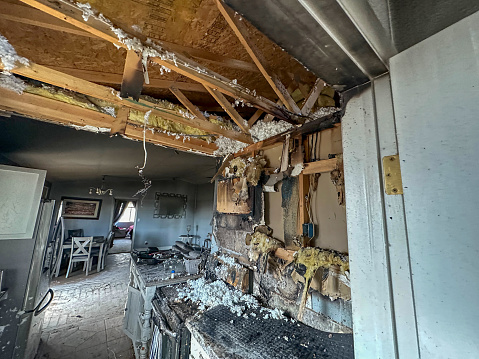 The old house is destroyed from the inside, with things scattered and walls and doors broken. A house in need of general repair. Crushed things in the room.
