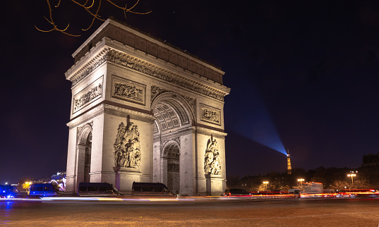 The Triumphal Arch and traffic flow at night in Paris, France