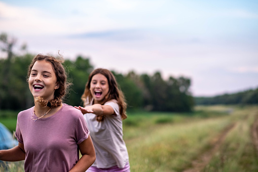 two teenage girls are walking in nature and laughing