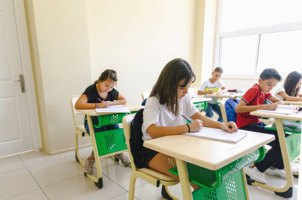 istock Concentrated School Children Engaged in Classroom Lesson 1952651954