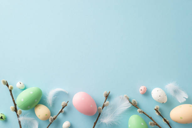 istock Cheerful Easter tableau: top view of bright eggs, feathers, fuzzy pussy willow on a pastel blue surface. Perfect for your text or advertisement 1952670186