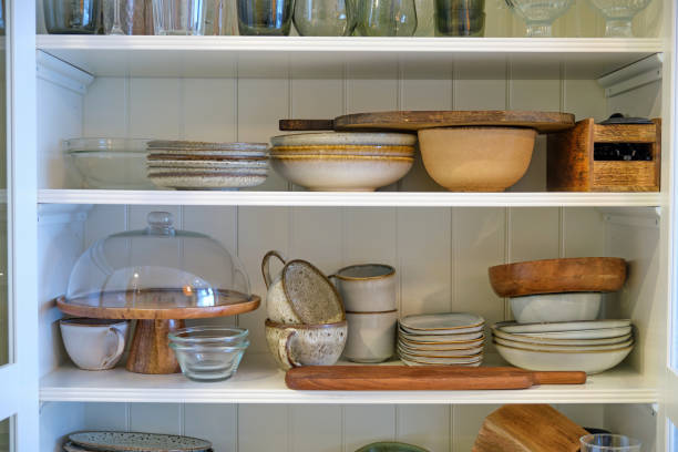 istock Filling the kitchen cabinet with clean dishes, plates and cups 1952684867