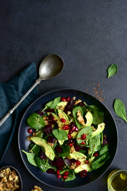 istock Spinach salad with avocado, beet root, walnuts and pomegranate seeds. To view with copy space. 1952684887