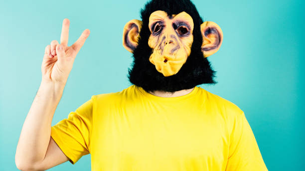 istock Monkey Mask Peace Sign Gesture Yellow T-Shirt Blue Background 1952685947