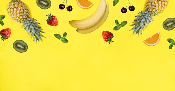 Fruit and berry on the yellow background. Copy space. Top view.