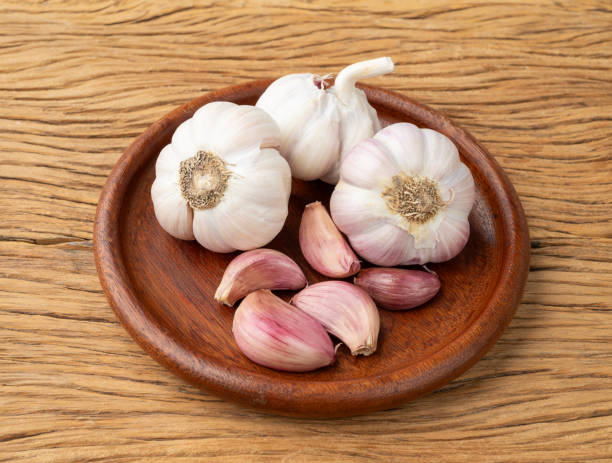 istock Garlic bulb and cloves on a plate over wooden table 1952693532