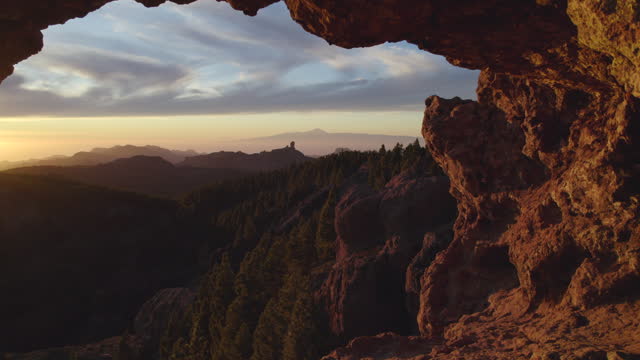 Cinematic shot through the window of Roque Nublo during sunset. You can see the majestic Teide volcano. Gran Canaria.