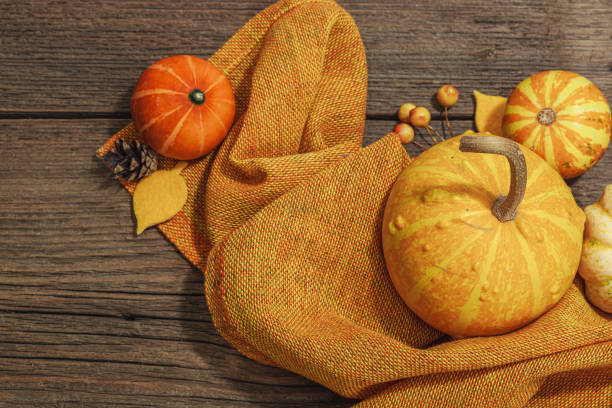 Autumn composition on wooden background. Assortment of decorative pumpkins, berries and fall leaves. Traditional symbol, festive design, top view