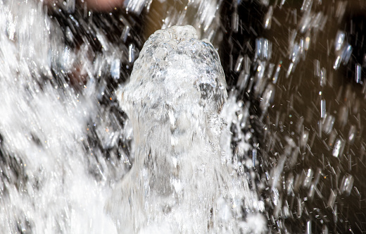 Close-up of a single water jet in a water fountain shot with a fast shutter speed creates an natural background image.