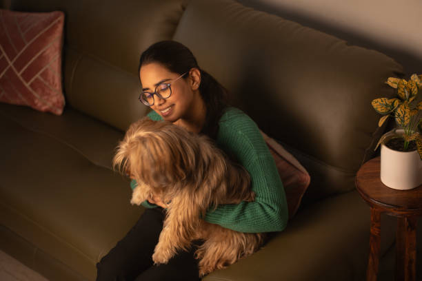 istock Smiling woman with dog on sofa 1952750221