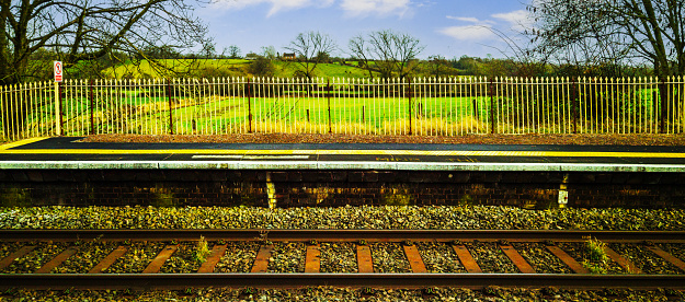 A station England UK. Diesel powered railway line in the English countryside. Station on a sunny day. Panoramic - Panorama.