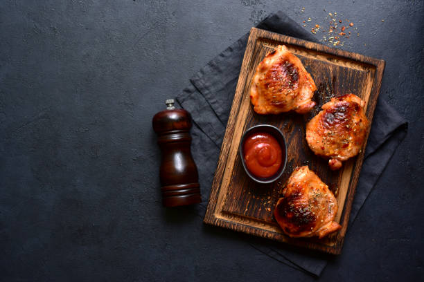 istock Roasted chicken thighs with ketchup. Top view with copy space. 1952772408