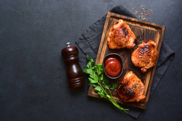 istock Roasted chicken thighs with ketchup. Top view with copy space. 1952772431