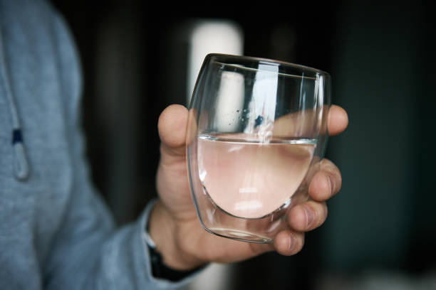 istock Man holds glass of clean water 1952823767