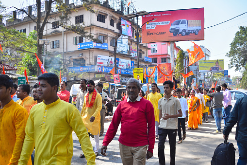 People participating in rally by foot with flag celebrating pran pratishtha of Lord Ram temple in Ayodhya.
