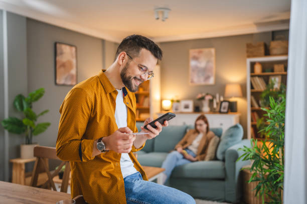 online shopping man hold credit or debit card make online purchase adult man at home shopping online use internet hold credit card e-banking online shop e-commerce paying stock pictures, royalty-free photos & images