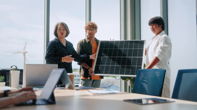 Eco-Conscious Business Team Showcasing Solar Panel during a Green Energy Strategy Meeting