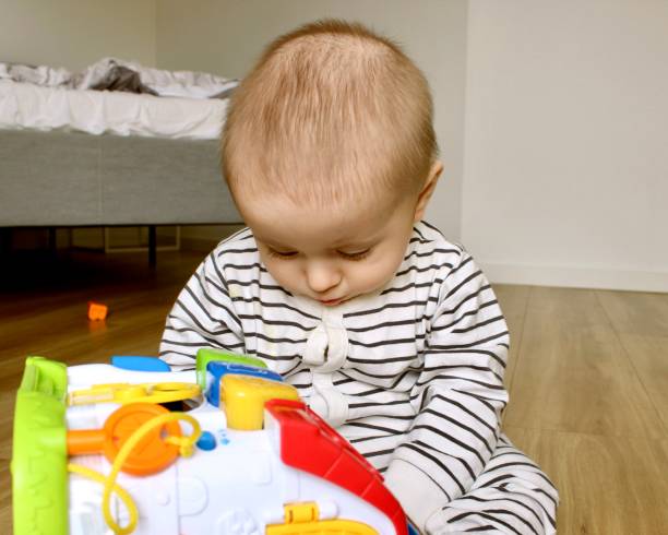 istock A handsome toddler boy is playing with toys in the room 1952837027
