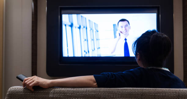 istock Woman watching TV in living room 1952852602