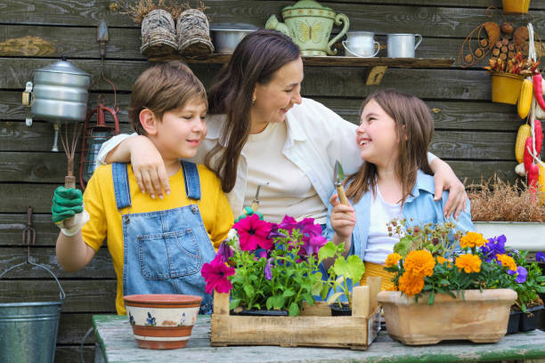 sprouting smiles: mother and children delight in the simple pleasures of soil, seeds, and sunshine as they engage in summertime gardening activities. - mother superior zdjęcia i obrazy z banku zdjęć