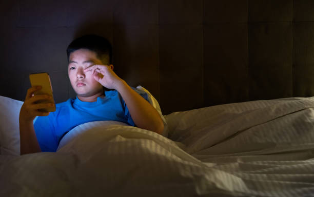 istock Teenage boys using mobile phone in bed 1952853679