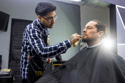 A gentleman getting a haircut and beard cut