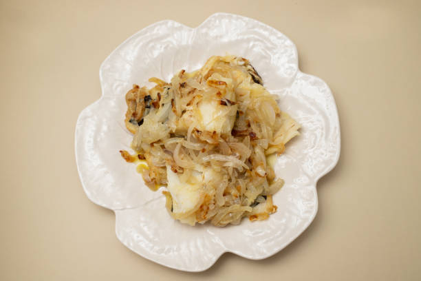 fried cod fish with onion and olive oil on plate fried cod fish with onion and olive oil on white plate fish fingers and salad stock pictures, royalty-free photos & images