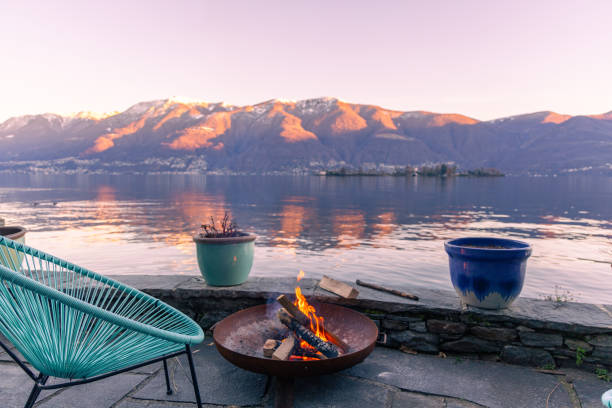 feuerstelle brennt am see, atemberaubende aussicht auf den lago maggiore, schweiz - fire pit fire camping burning stock-fotos und bilder