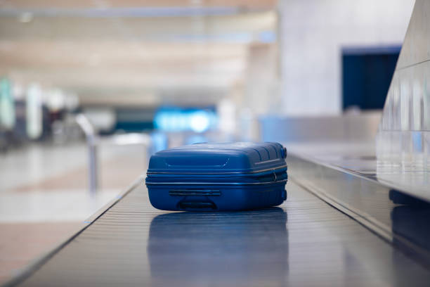 Lonely blue suitcase on baggage claim at airport Traveling by airplane. Selective focus on lonely blue suitcase on baggage claim in airport terminal. sorter machine stock pictures, royalty-free photos & images