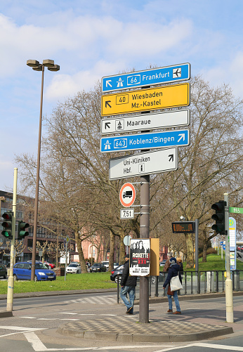 Mainz, Germany-March 28,2015:Road Signs, directions, Traffic Lights and People near River Rhine