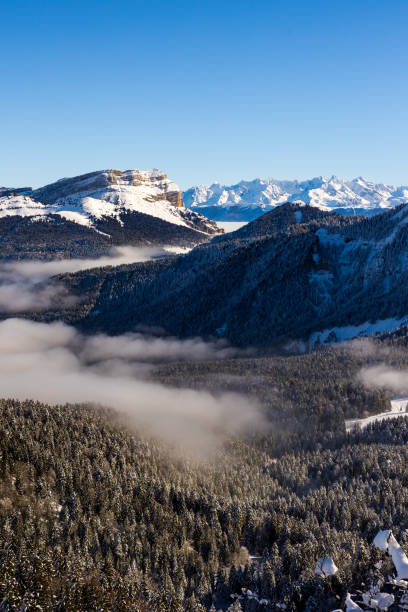 summit of dent de crolles and belledonne range from charmant som, in the chartreuse regional natural park, covered in snow above a sea of clouds - crolles imagens e fotografias de stock