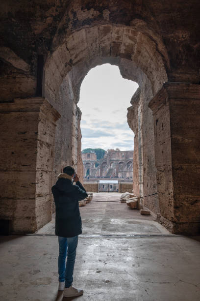 istock Person Taking Photo Through Ancient Archway in Rome 1952931106