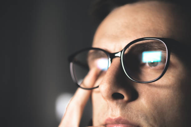 istock Tired man in glasses works on internet. Migraine or headache after work in front of computer all day. Eye pain, dry eye syndrome. 1952937422