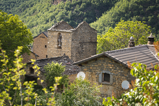 Views of the roofs of a small abandoned village in ruins in the middle of the mountain and a bell tower